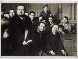 black and white photograph of a group of men sitting in a courtroom