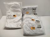 three bags of white shirts sitting on top of a white table