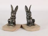 une paire de serre-livres en bronze représentant des lapins, posés sur des socles en marbre