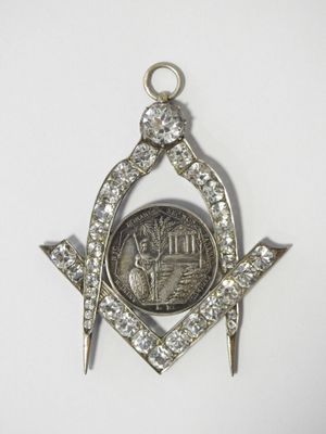 un gros plan sur une médaille d'argent avec une pièce au centre