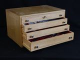 une boîte en bois surmontée de trois tiroirs