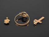 three gold rings and a cross on a black surface
