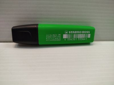 un stylo vert posé sur une surface blanche