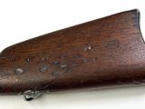 an old wooden rifle is laying on a white surface