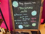 a chalk board with a menu on it in front of a pink wall