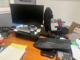 a desk with a computer, keyboard, mouse, and other items on it