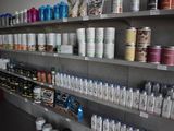 many cans of paint on the shelves in the store