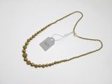 a close up of a gold beaded necklace with a tag on it