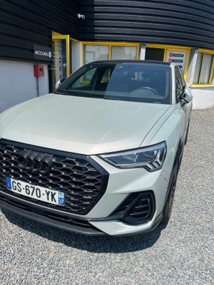 l'avant d'un SUV Audi blanc garé devant un immeuble