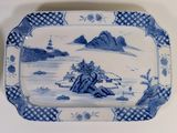 a blue and white platter with a landscape on it