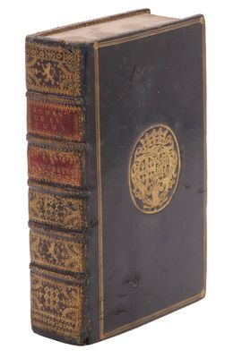 un vieux livre noir orné d'un médaillon doré sur la couverture