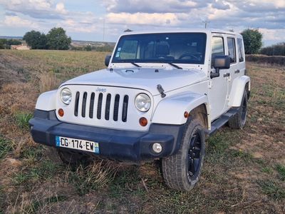 a white jeep parked in the middle of a field