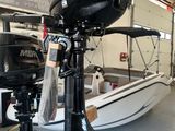deux moteurs hors-bord posés sur un support dans un magasin de bateaux