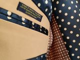 the polka dot pattern is on the jacket and tie of the man