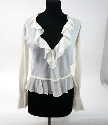 a white blouse with ruffles on a mannequin