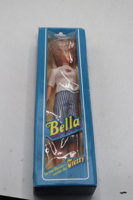 une poupée Barbie dans une boîte bleue posée sur une table blanche