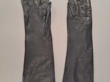 two pairs of black leather gloves sitting on top of a table