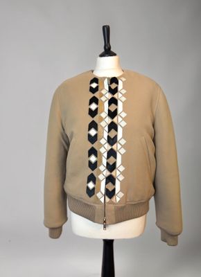 jacket on a mannequin stand with a black and white tie on it
