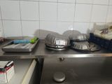 several pans and pans on a stainless steel shelf in a kitchen
