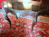 a table with a glass top on a red rug
