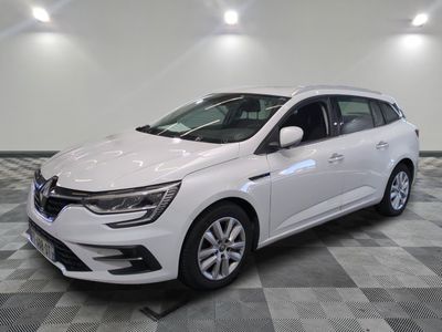 une voiture blanche est garée dans une pièce au sol à carreaux