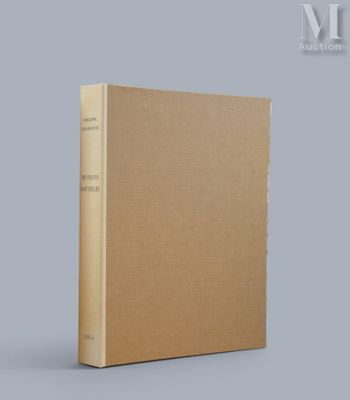 un livre marron posé sur une table près d'un mur gris