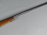 a rifle with a wooden barrel and a metal handle