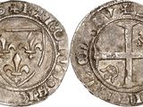 a silver coin with a cross on the front and a shield on the back