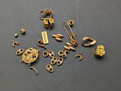 quelques bijoux en or sont posés sur une surface noire