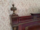 a bed with a wooden headboard and a vase on top of it