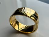 a close up of a gold ring on a white surface