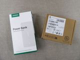 une photo montrant une boîte de batterie externe à côté d'une boîte de piles