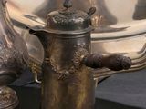 une théière en argent et une théière en argent posées sur une table