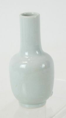 a small white vase sitting on a clear surface