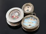 three small watches sitting on top of a black table