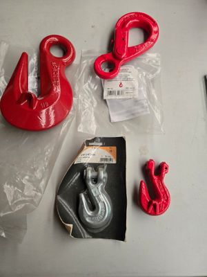 quelques crochets rouges et une paire de ciseaux posés sur une table