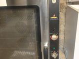 a silver oven sitting on the floor next to a white refrigerator