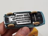 a person holding a small toy car in their hand