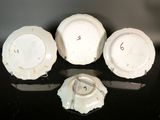 three white porcelain plates with numbers on them sitting on a table