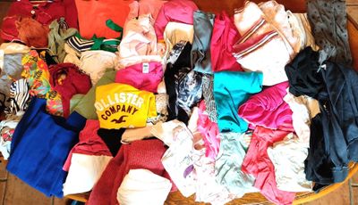 un panier rempli de vêtements posé sur un sol carrelé
