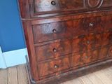 a wooden dresser with a marble top in a blue room