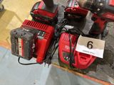 two red power tools sitting on the floor next to each other