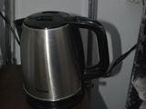 a kettle that is sitting on a shelf next to a bed