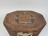 a wicker box with a handle on a white background
