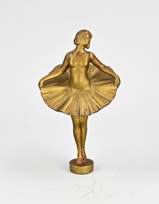 brass statue of a woman with a tutu skirt on a pedestal
