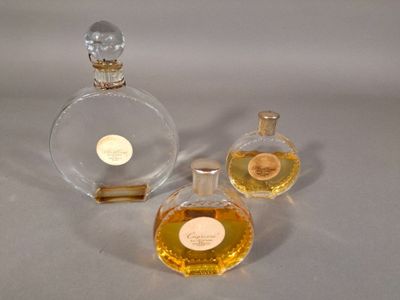 trois flacons de parfum posés l'un à côté de l'autre sur une table