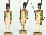 three figurines of soldiers with weapons and uniforms on wooden bases