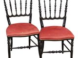 pair of black painted chairs with red upholstered seats