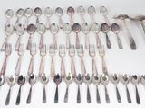 a lot of spoons and forks laid out on the table