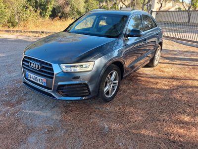 a grey audi qx parked on a dirt road in front of a fence